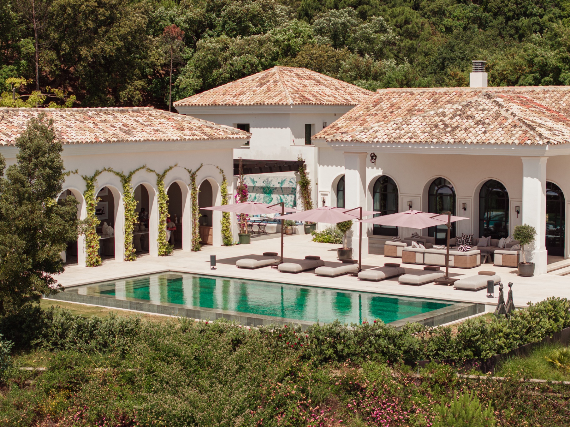 The infinity pool and pool house at Casa Servetta framed by Mediterranean arches.