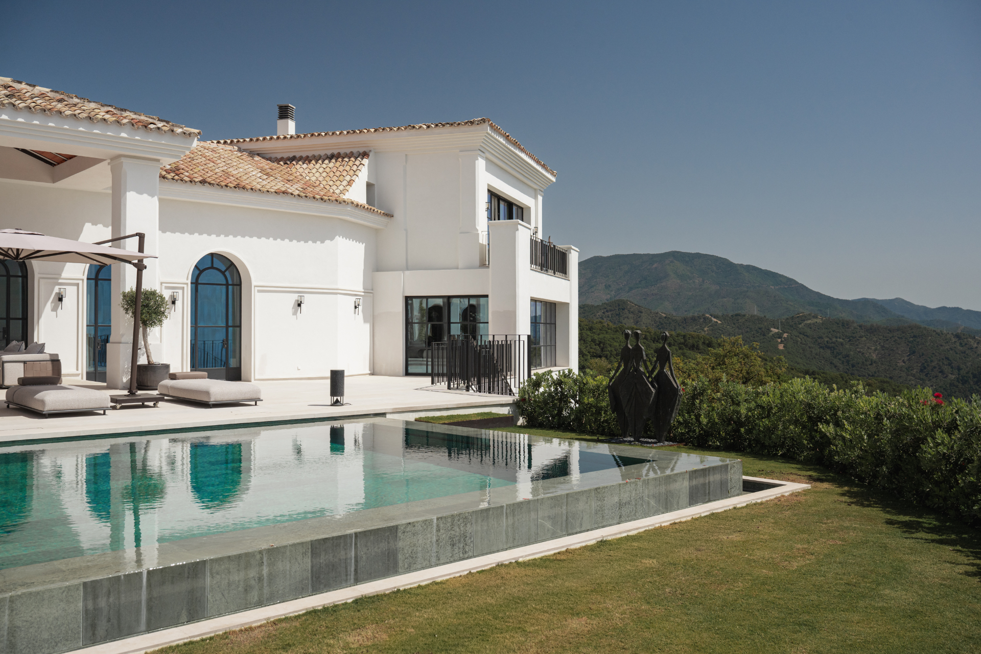 The villa's white facade reflected in the pool.
