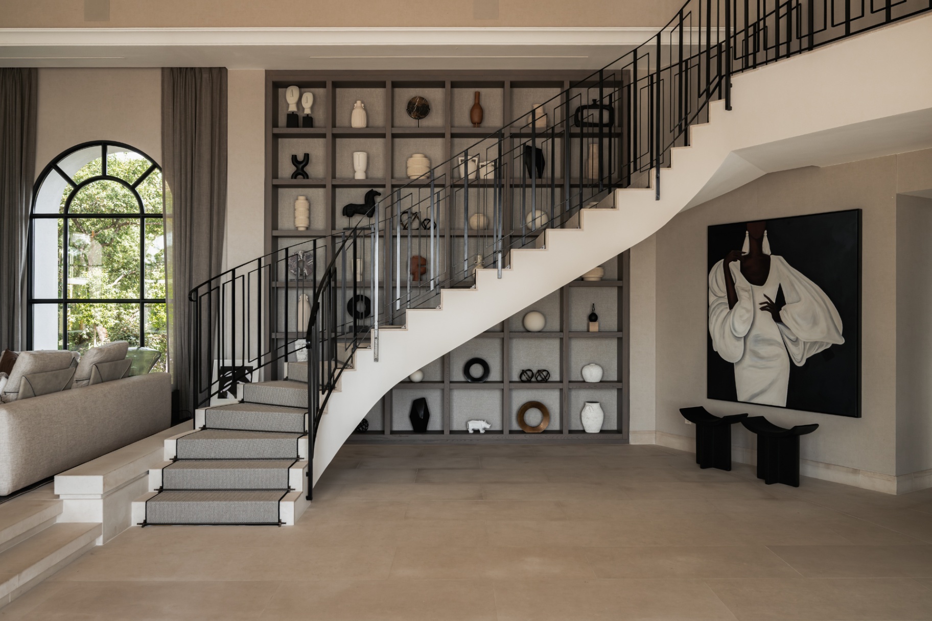 Sculptural white staircase against a shelving wall.