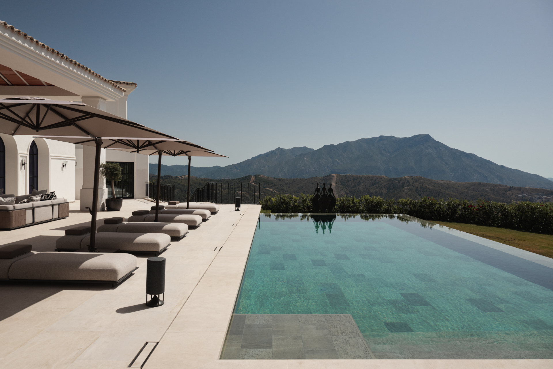Infinity pool with loungers facing La Concha mountain.