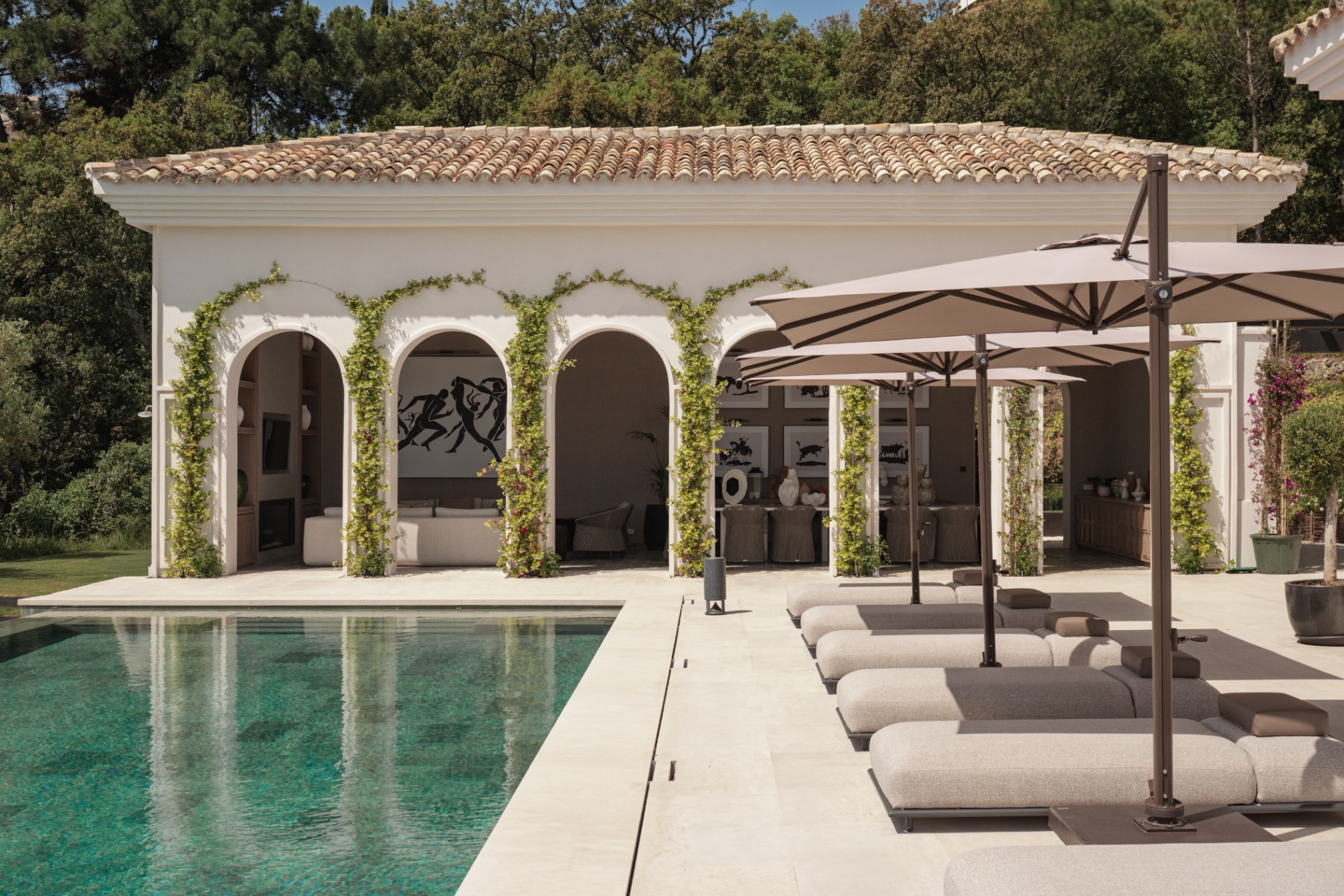 Arched pool house draped in climbing greenery.