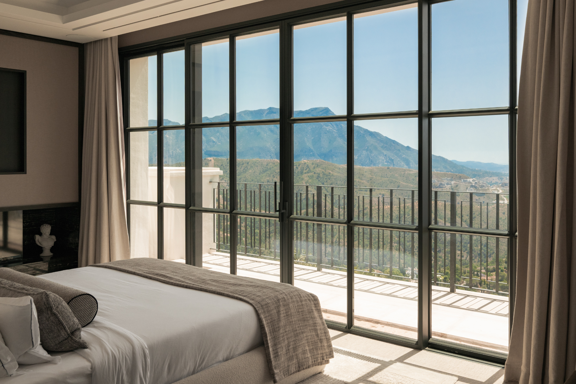Bedroom opening to a mountain-view balcony.